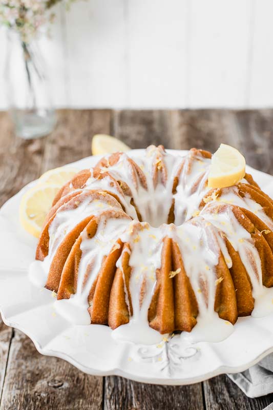 Looking for an easy dessert that will impress your guests at your next summer gathering? This Southern Sweet Tea Lemon Cake is light, fluffy, sweet, and tastes like everything summer! Southern sweet tea lemon cake on a wood picnic table