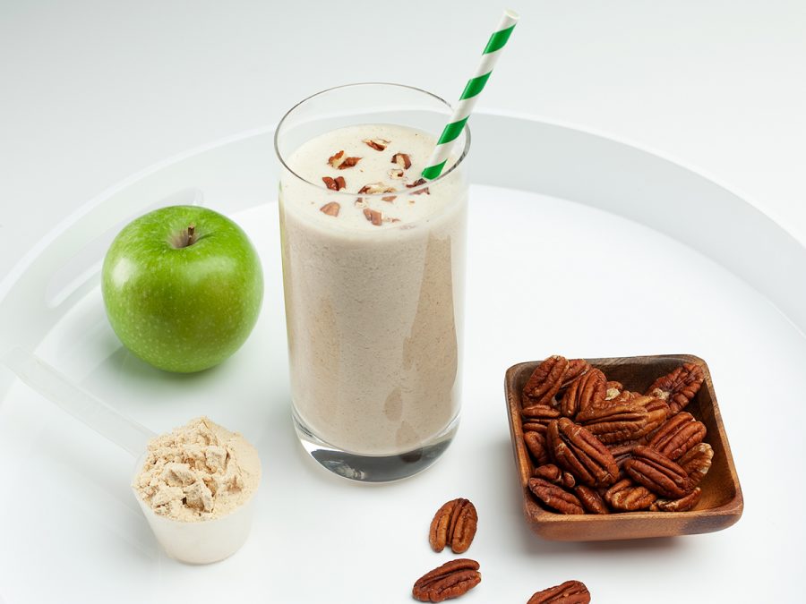 Arbonne Vanilla Protein Shake on a white surface with ingredients for the shake.