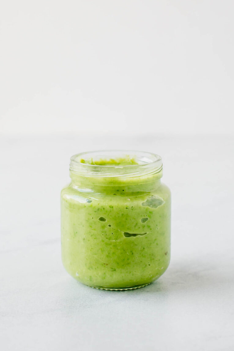 Baby food made with peas and avocado in a jar.