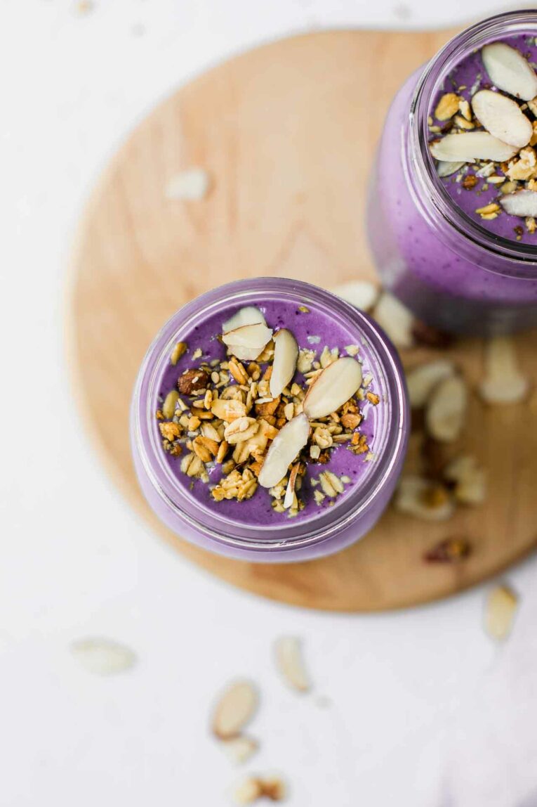 Creamy, sweet, tasty, and one of the BEST protein shakes out there! This Blueberry Vanilla Protein Shake Recipe is made with fresh or frozen blueberries, creamy greek yogurt, your choice of milk, and vanilla protein powder. Make this easy snack or breakfast in 5 minutes or less! Top shot of blueberry vanilla protein shake.