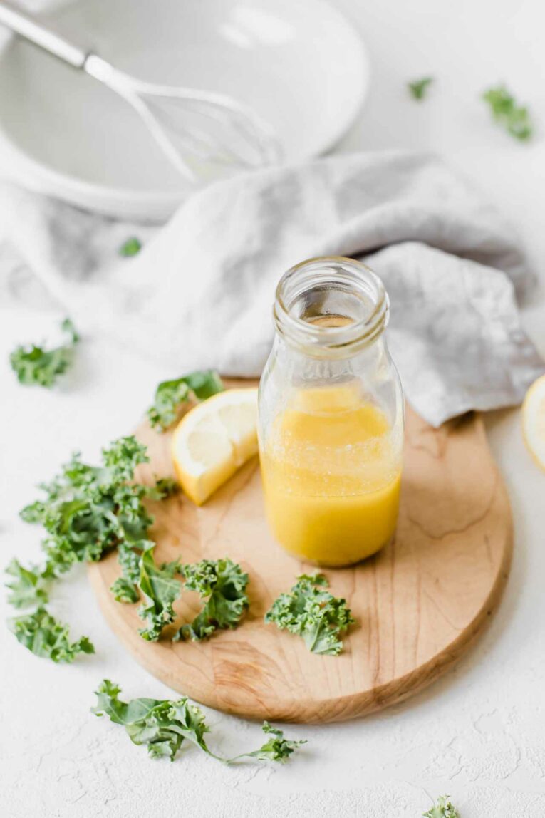 Angled shot of an easy, classic lemon vinaigrette on a wooden cutting board.
