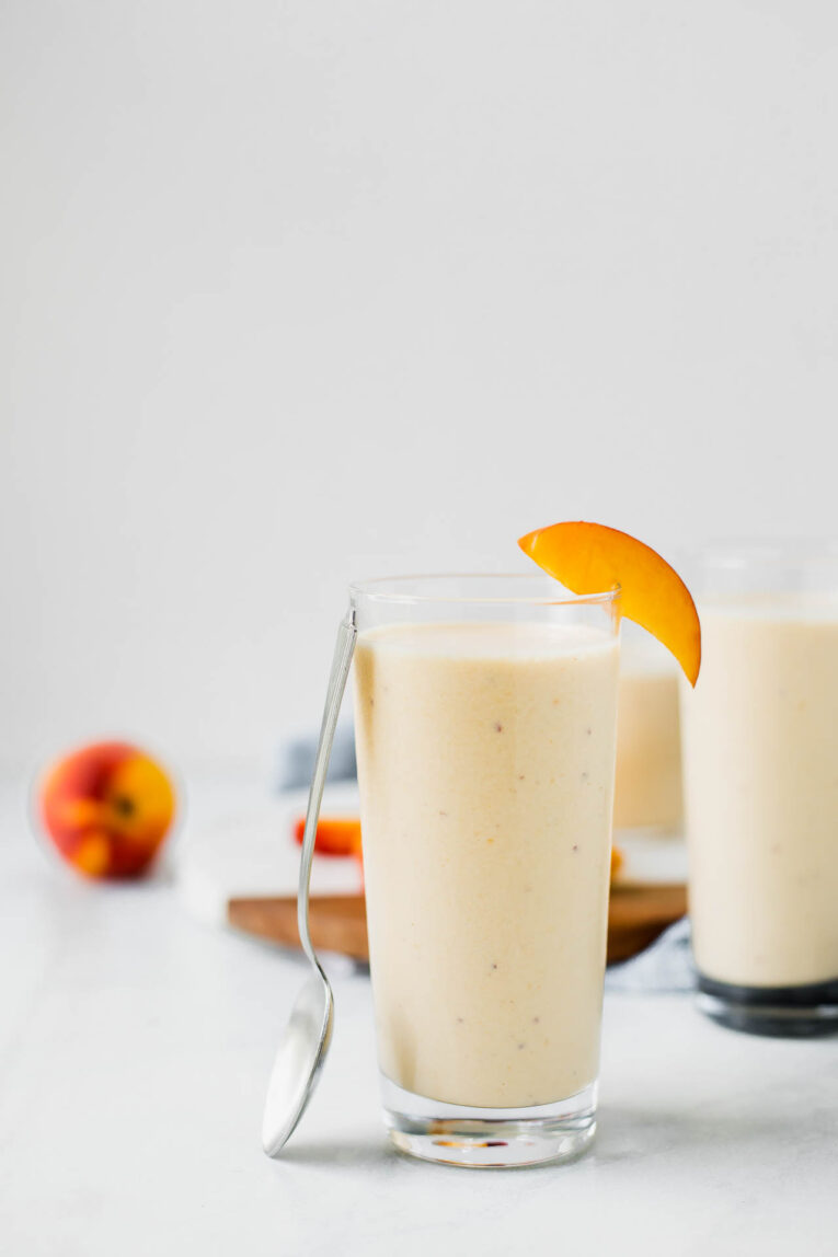  Peach Yogurt Smoothie in a glass with a spoon