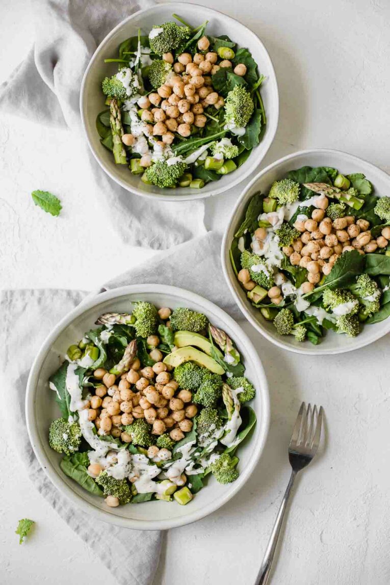 Easy to make simple chickpea salad in 3 bowls on a white table.