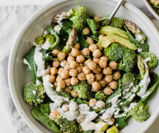 Simple green goodness chickpea salad in a white bowl with a fork.