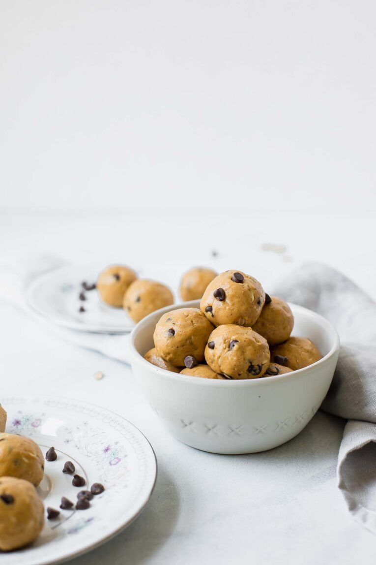 The BEST Peanut Butter Energy Balls that only take about 10 minutes to make. Keep these healthy bites on hand for easy snacking or take them on-the-go! (Vegan, vegetarian, gluten-free, dairy-free, refined sugar free) Peanut butter energy bites in a white bowl.