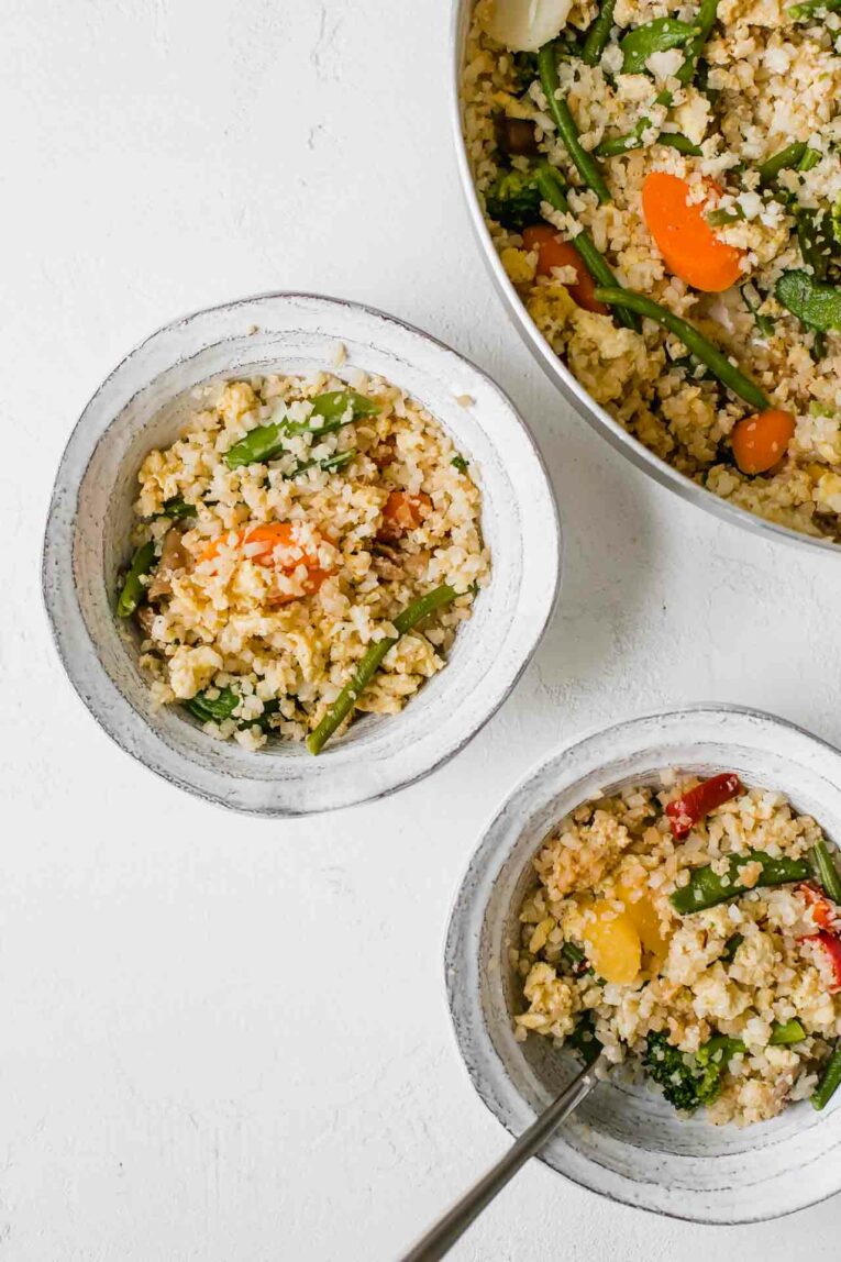 The Best Cauliflower Fried Rice that's perfect for dinner tonight! This 10-minute recipe is easy to make, gluten-free, dairy-free, vegetarian, and great for the entire family. The Best Cauliflower Fried Rice served in two bowls