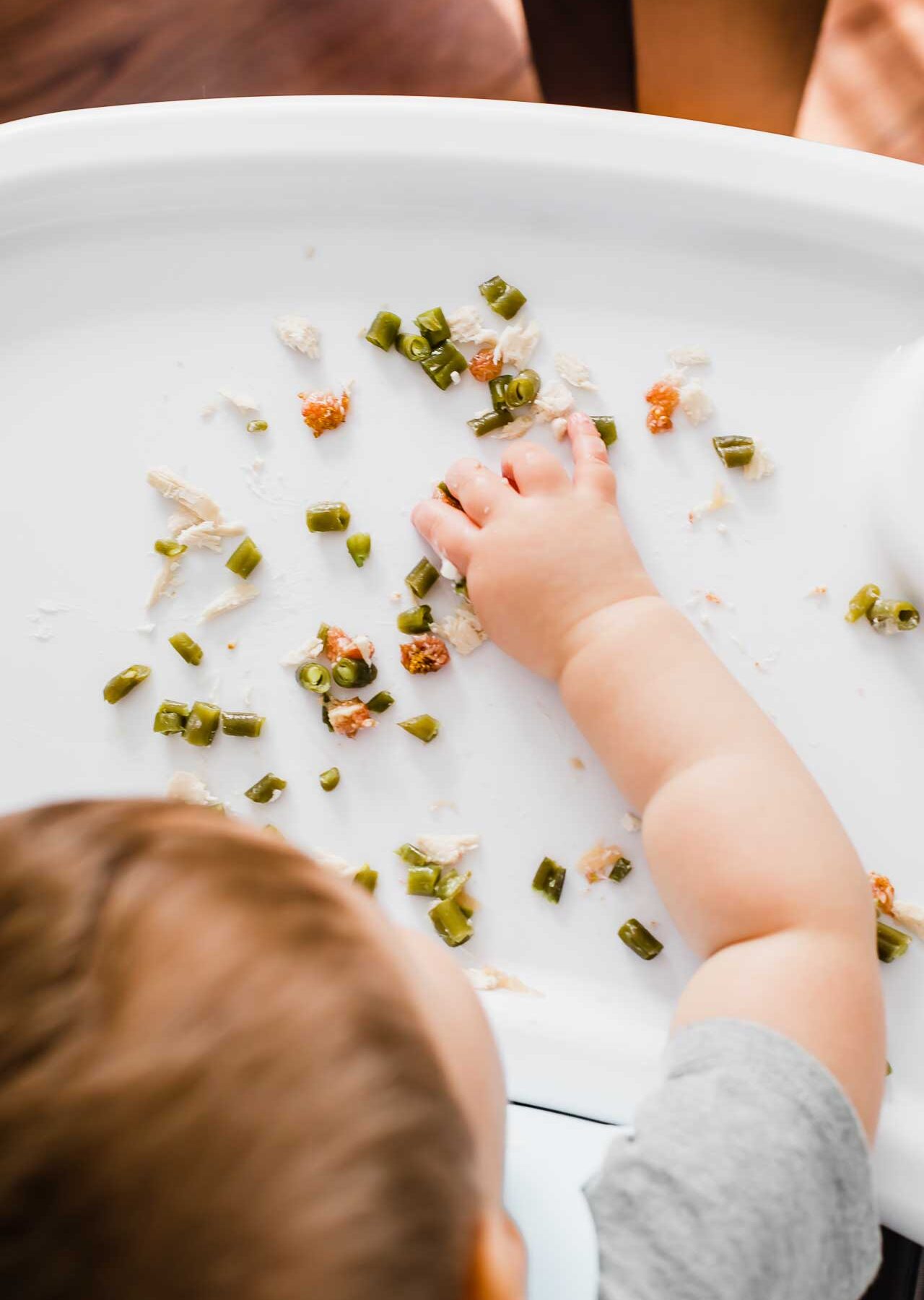 Toddler eating baby led weaning food.