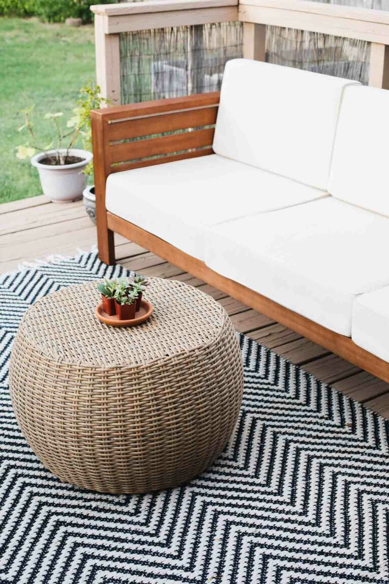 Small spaces can be everything you want them to be! Today, we're sharing our favorite inspiration and decorating ideas for a small deck! World market outdoor sofa, rug, and round coffee table.