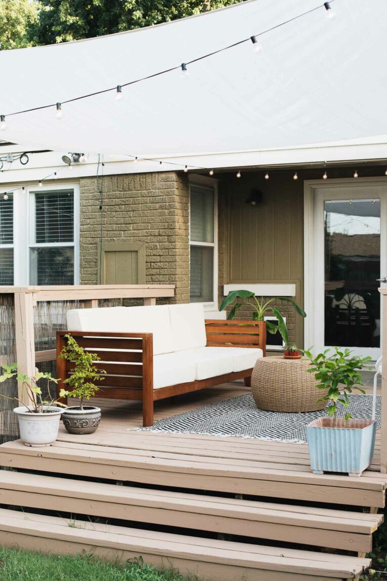 A deck image with a couch and a rug and coffee table.