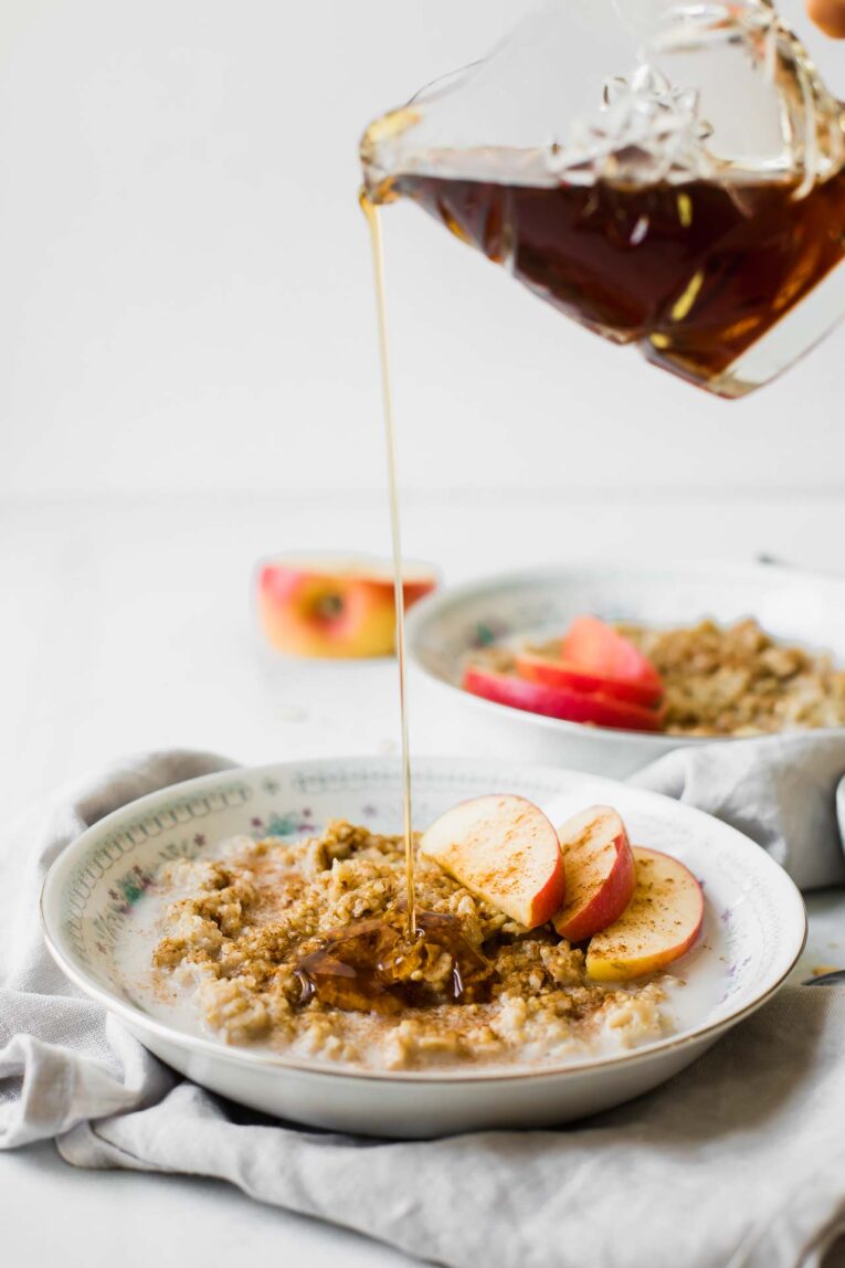 Sweet, wholesome, delicious, and easy to make. We're loving this simple Apple Cinnamon Quinoa Breakfast Bowl for a healthy start to the day! Maple syrup drizzle over a quinoa oatmeal breakfast bowl.