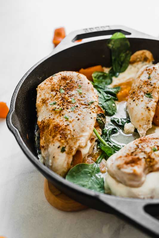 Close up of apricot mozzarella stuffed chicken in a skillet.
