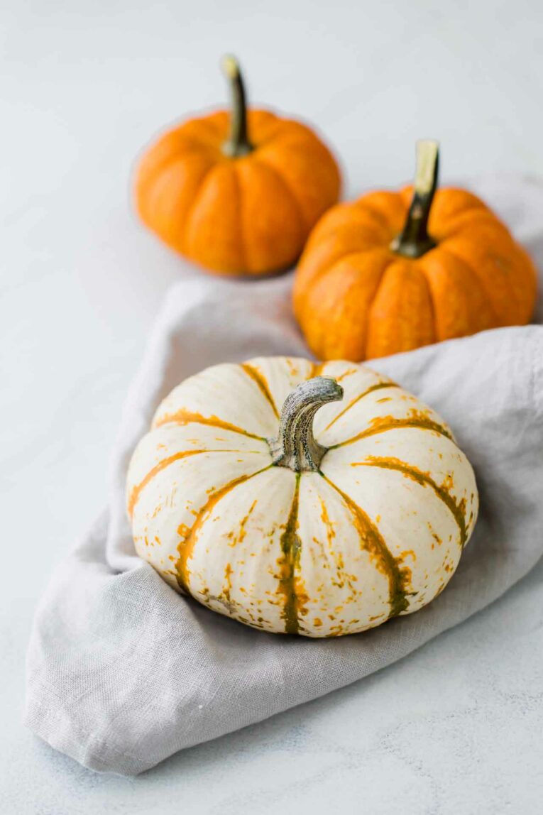Three mini pumpkins on a grey napkin.