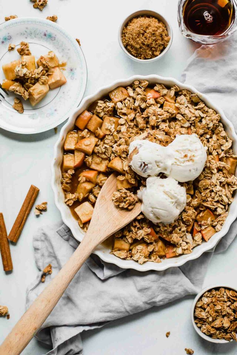 Top shot of Healthy Apple Crisp served with oats, maple, and ice cream.