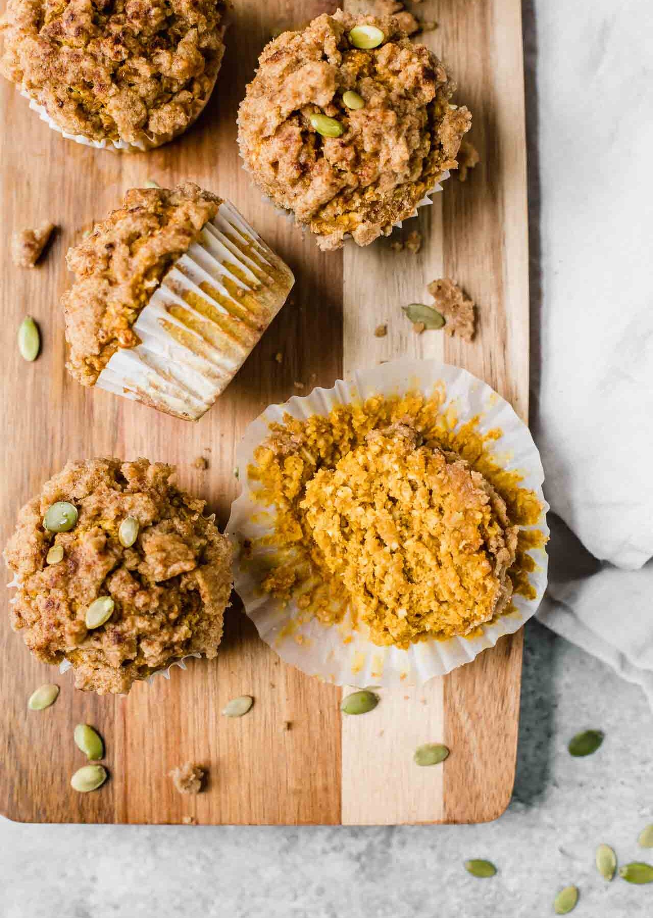 Healthy Pumpkin Muffins recipe on a cutting board with pepitas.