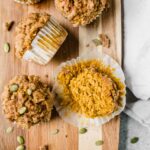 Healthy Pumpkin Muffins recipe on a cutting board with pepitas.