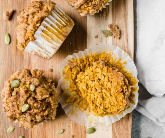 Healthy Pumpkin Muffins recipe on a cutting board with pepitas.
