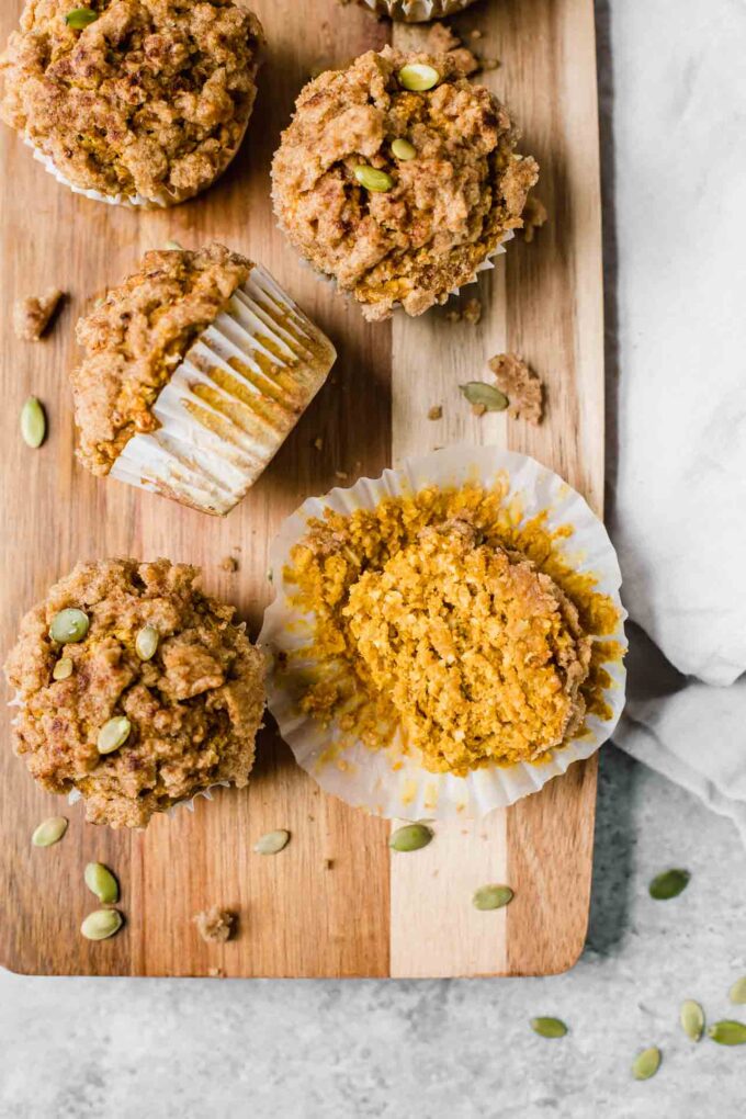 Healthy Pumpkin Muffins recipe on a cutting board with pepitas.