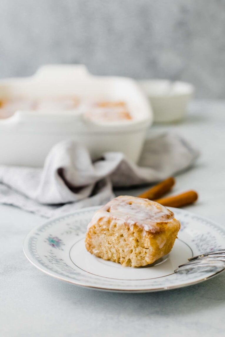 Vegan cinnamon roll on a white, floral plate.