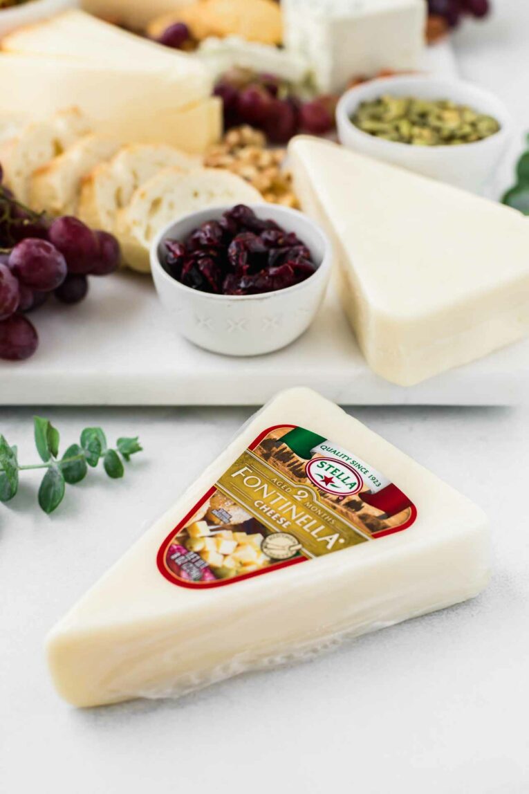 Stella Fontinella Cheese next to a marble cheese board.