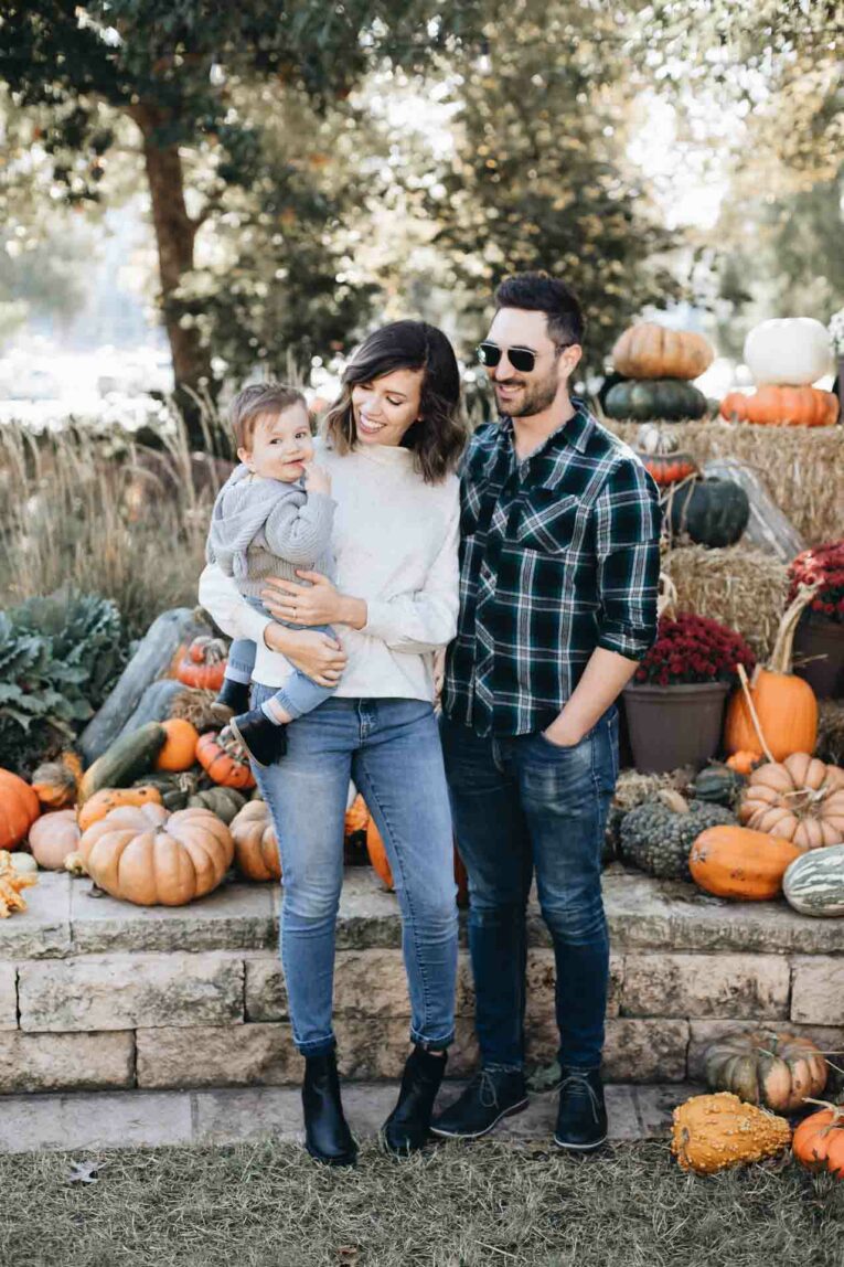 Family with baby at a pumpkin patch.