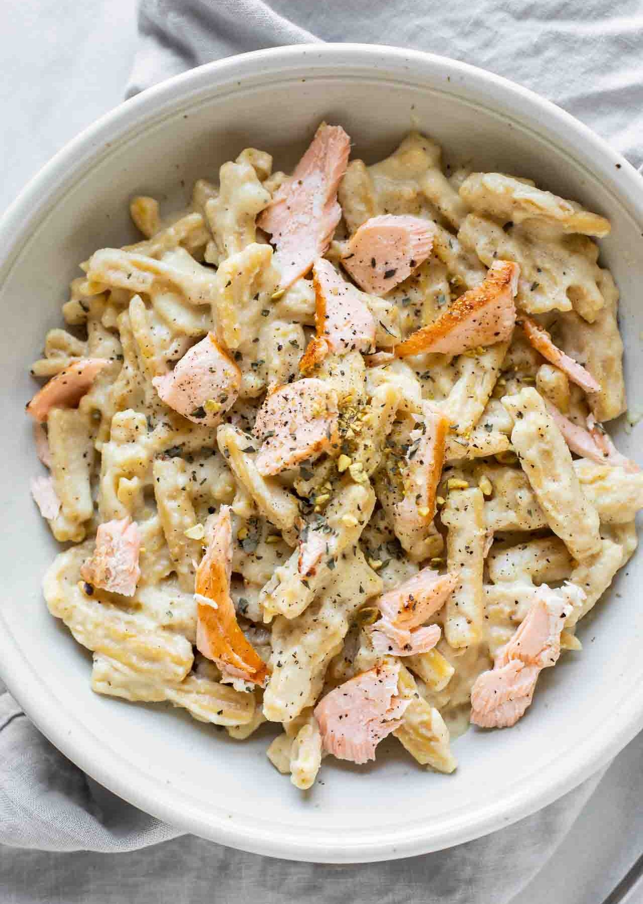 Close up of salmon pasta topped with a creamy sauce.