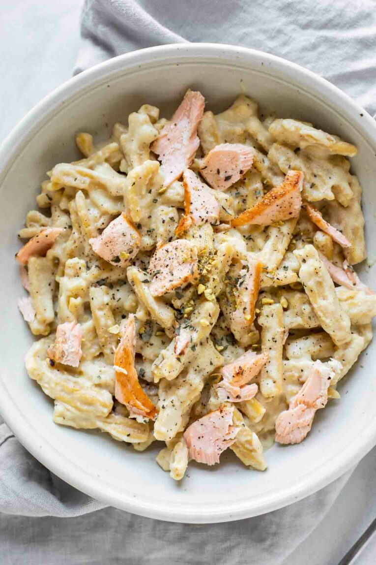 Close up of salmon pasta topped with a creamy sauce.