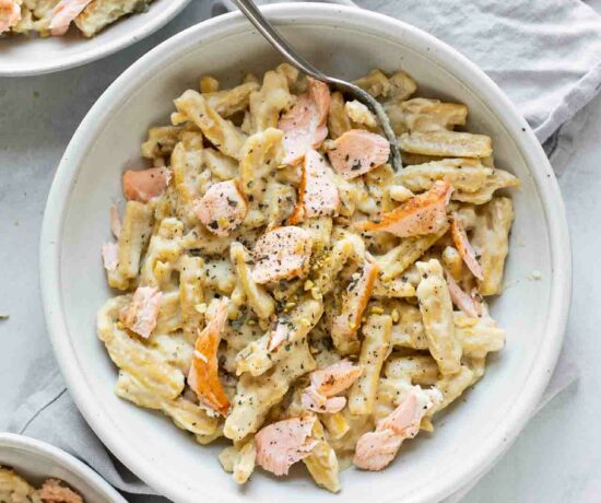 Top shot of Creamy Salmon Pasta in a white bowl with a fork.