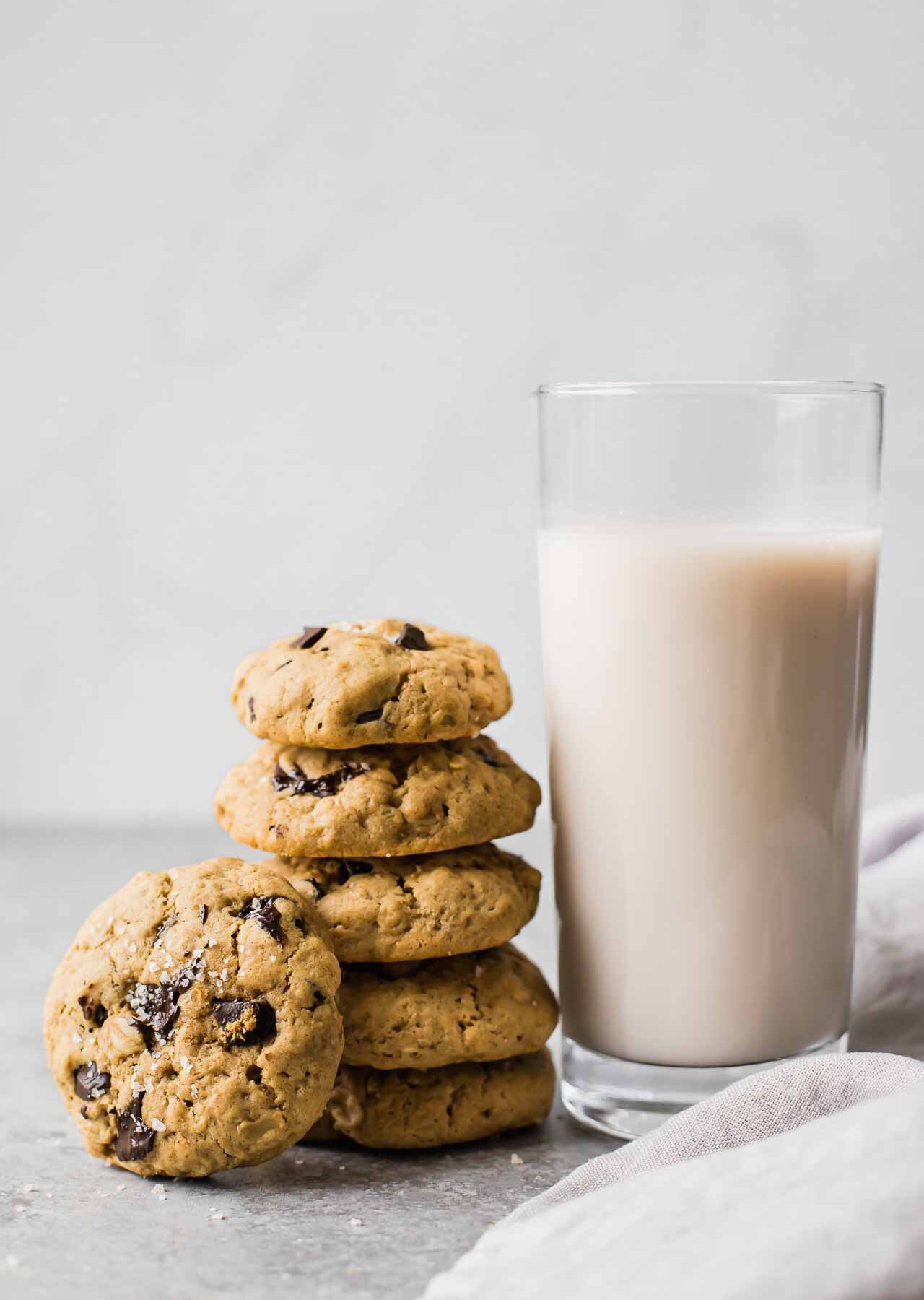 Healthy oatmeal chocolate chip cookies next to a glass of milk.