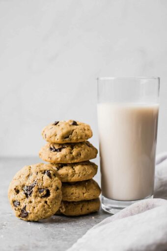 Healthy oatmeal chocolate chip cookies next to a glass of milk.
