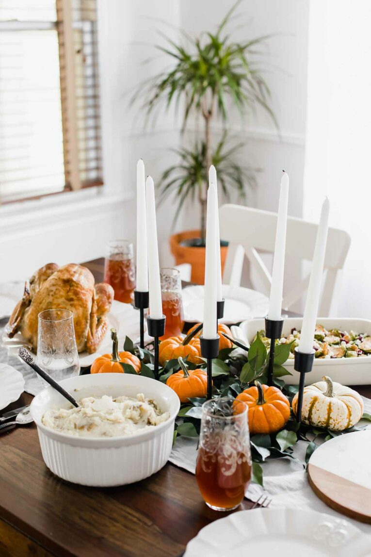 Thanksgiving tablescape on a wood table with a grey runner.