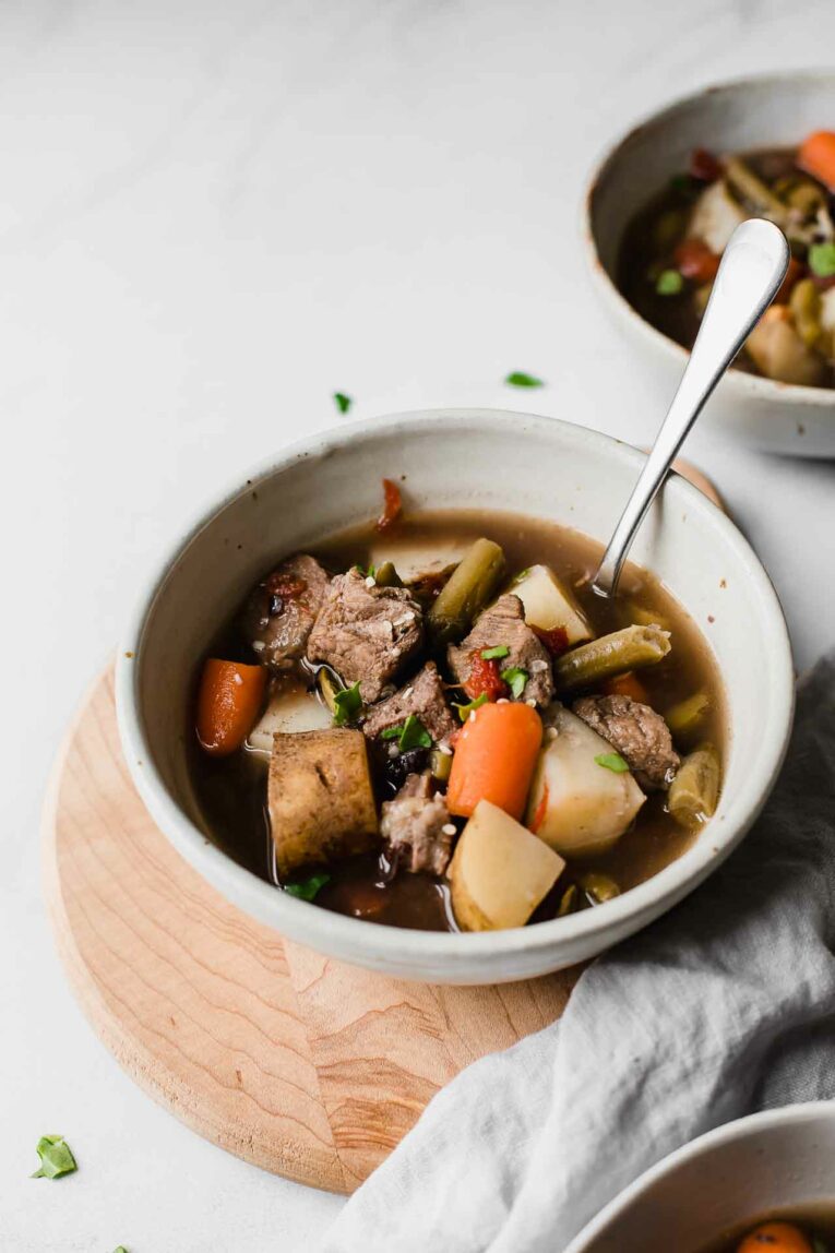 Angled shot of beef stew with chuck roast, potatoes, carrots, and green beans.