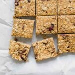 Cranberry Almond Healthy Oatmeal Bars on white parchment paper.