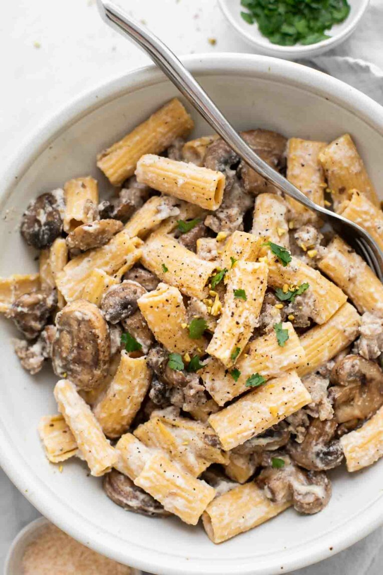Close up of whole wheat rigatoni, sausage, mushrooms, and a creamy sauce.