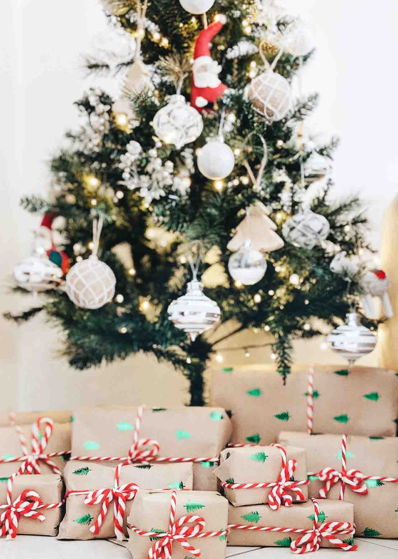 Wrapped gifts on the floor with decorated Christmas tree in the background.
