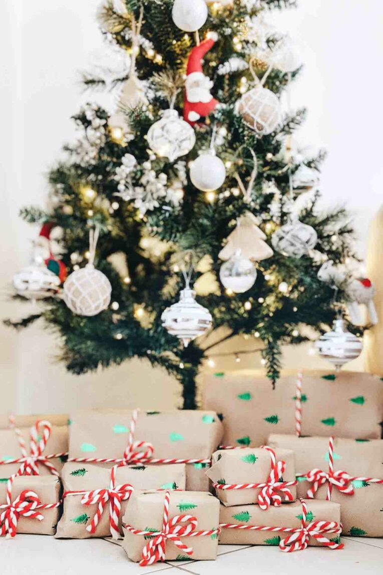 Wrapped gifts on the floor with decorated Christmas tree in the background.