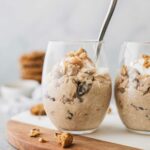 Oatmeal Cookie overnight oats in two glass cups with a spoon.