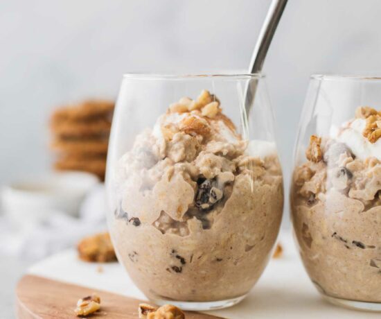 Oatmeal Cookie overnight oats in two glass cups with a spoon.