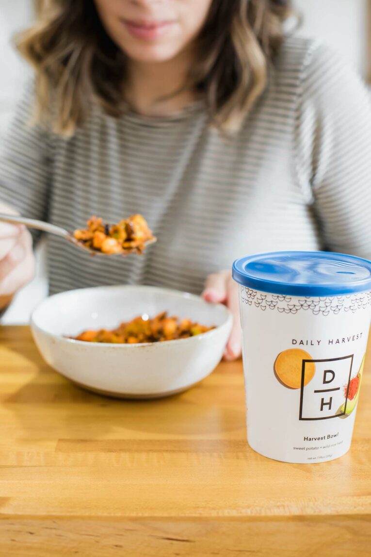 Daily Harvest harvest bowl with woman in the background.