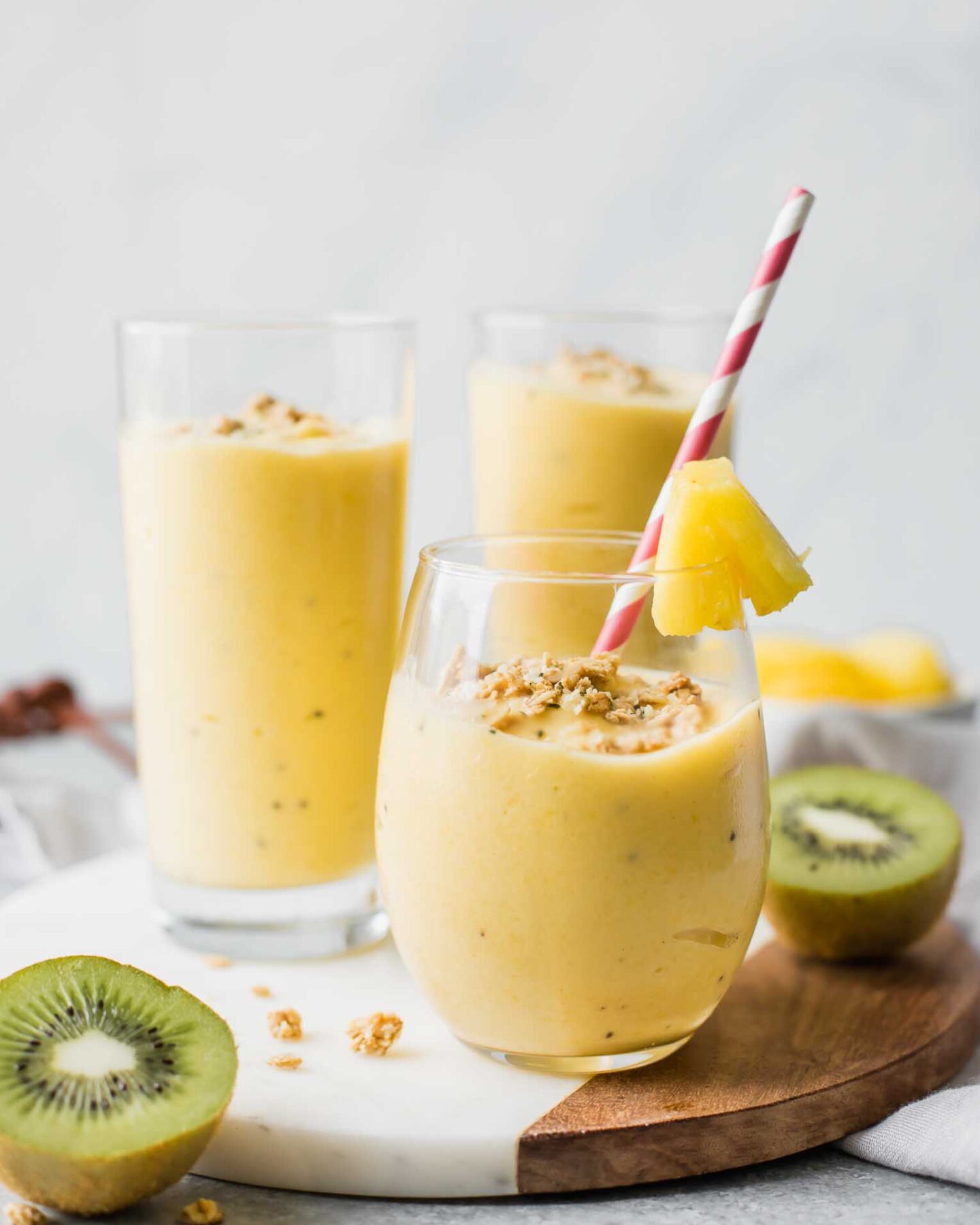 Across shot of a tropical smoothie in a glass cup with smoothies in the background.