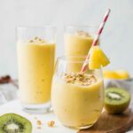 Across shot of a tropical smoothie in a glass cup with smoothies in the background.