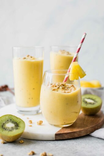 Across shot of a tropical smoothie in a glass cup with smoothies in the background.