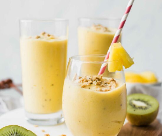 Across shot of a tropical smoothie in a glass cup with smoothies in the background.