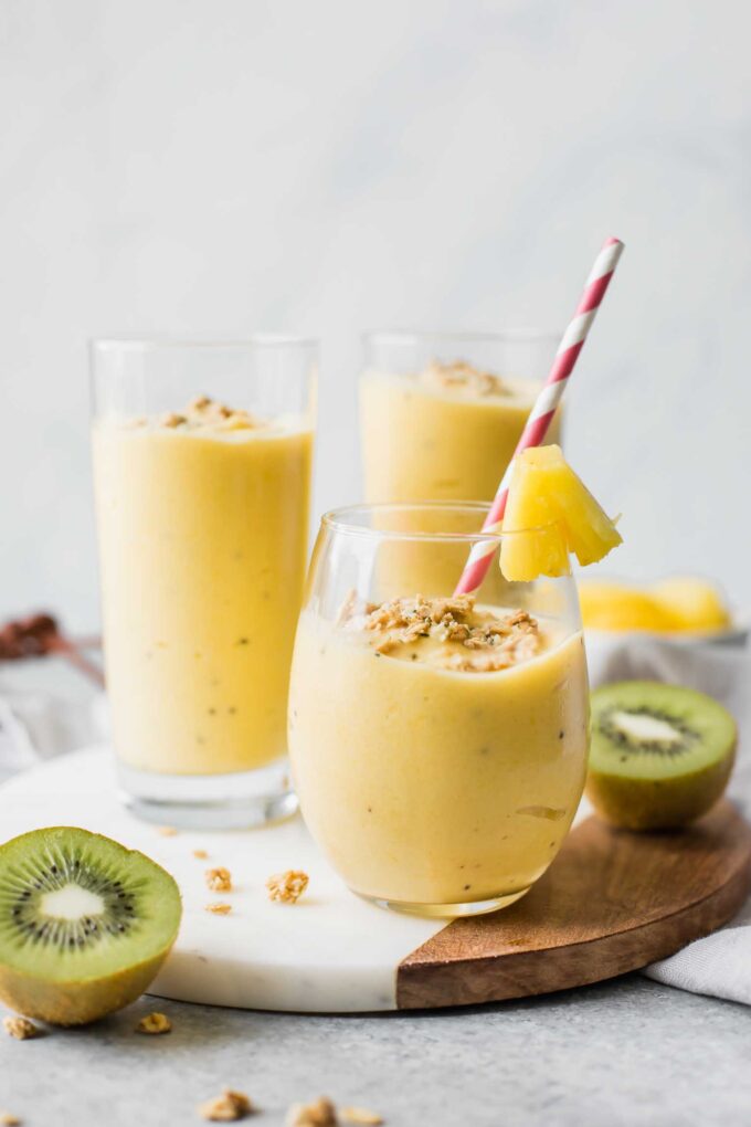 Across shot of a tropical smoothie in a glass cup with smoothies in the background.