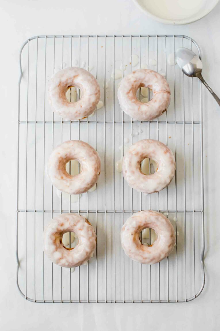Top shot of glazed doughnuts on a cooling tray.