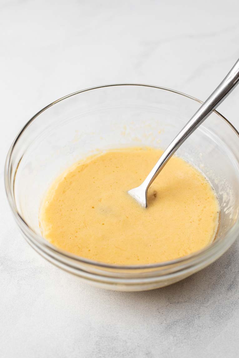 Liquid ingredients in a small glass mixing bowl, mixed together.
