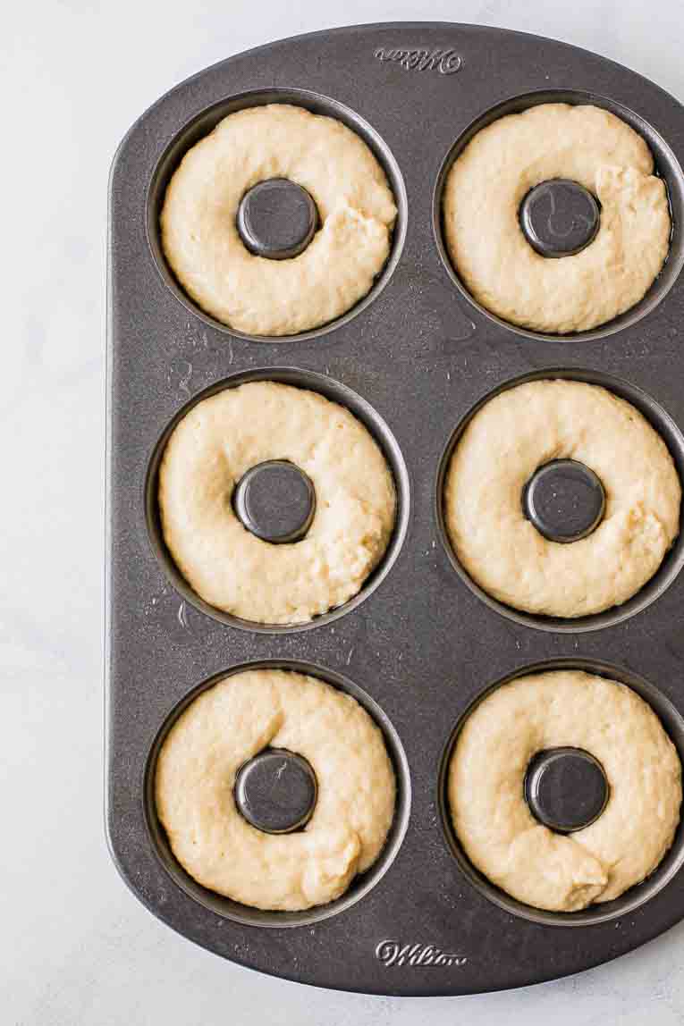 Doughnut dough piped into a doughnut pan.