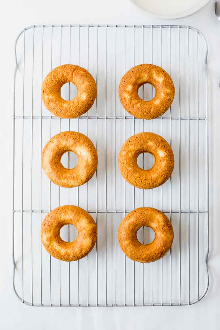 Baked doughnuts on a cooling tray.