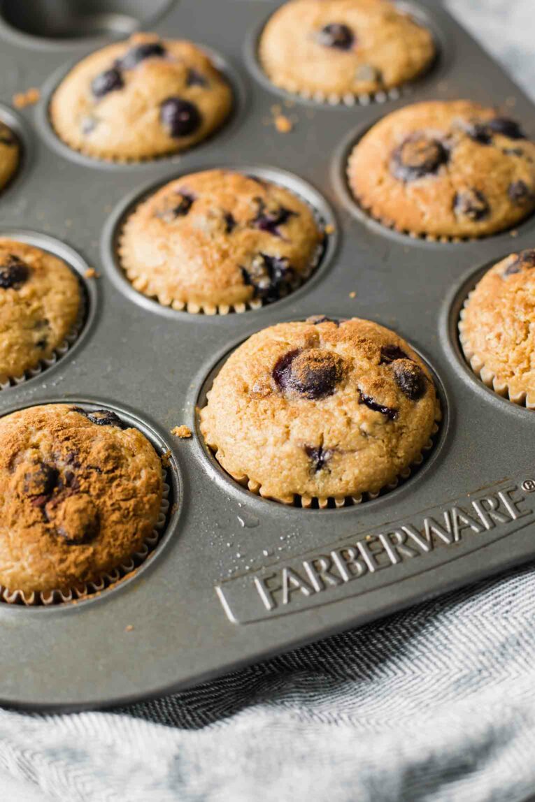 Angled shot of Blueberry Quinoa Muffins freshly baked in a muffin tin.