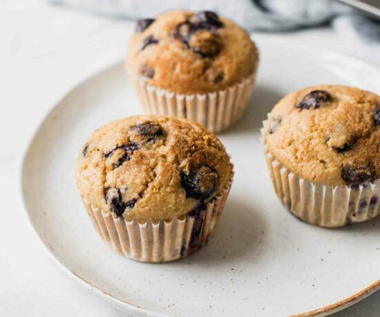 Angled shot of Blueberry Quinoa Muffins on a white plate with a napkin in the background.