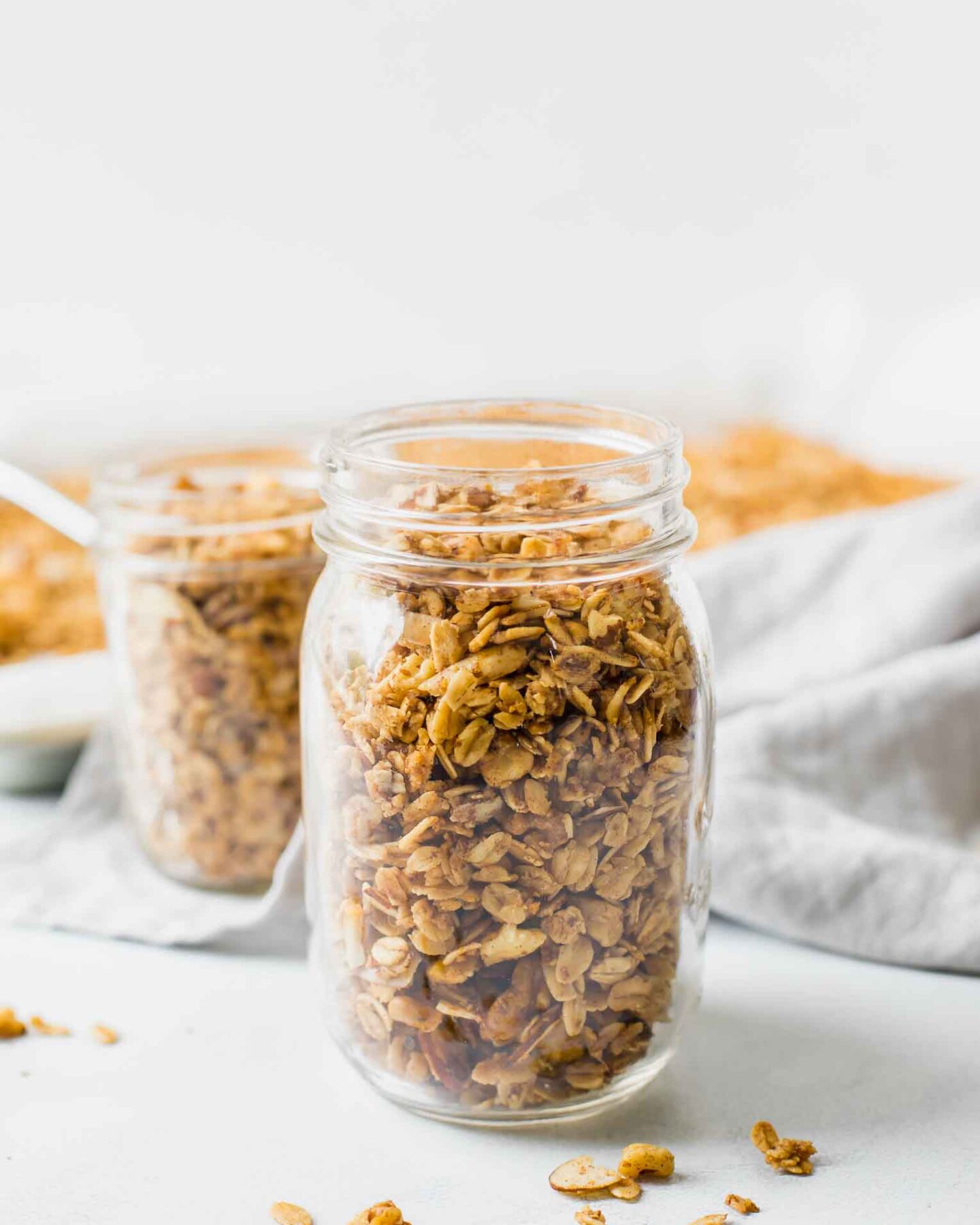 Healthy Homemade Granola in a mason jar with a grey napkin in the background.